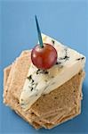 Morceau de fromage bleu avec raisin rouge sur des craquelins