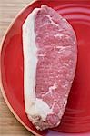 Fresh beef steak on red plate