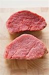 Two beef medallions on chopping board