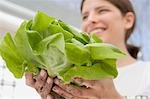 Young woman holding fresh lettuce from the garden