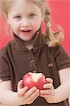 Little girl holding a partly eaten apple