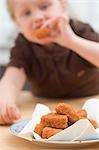 Petite fille manger des croquettes de poulet