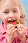 Kleine Mädchen essen Erdbeere