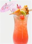 Cocktail avec parasol et brochette de fruits exotiques