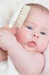 Main se brosser les cheveux de bébé avec une brosse douce