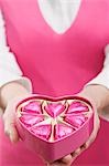 Woman holding box of heart-shaped chocolates