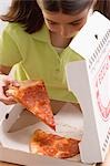 Little girl taking slice of pizza out of pizza box