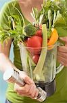 Femme tenant la main poids & de légumes frais dans le bol