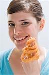 Young woman with deep-fried onion rings on index finger