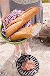 Frau mit Baguette zu einem Barbecue am Ufer eines Flusses