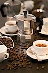 Espresso maker, cups of espresso and coffee beans