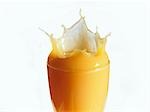 Mango nectar splashing out of a glass