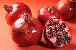 Several pomegranates, whole and halved