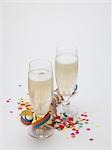 Deux verres de vin mousseux, banderoles de papier et confetti