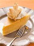 Piece of pumpkin pie with cream and pastry leaf