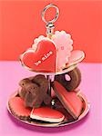 Heart-shaped biscuits with pink & red icing & chocolate cakes
