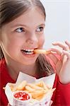 Mädchen hält eine Tüte Chips und Essen einen chip