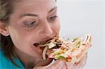 Junge Frau beißt in ein Stück Gemüse pizza