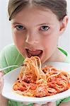 Fille manger spaghetti avec boulettes de viande