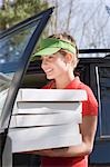 Smiling woman with several pizza boxes