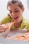 Jeune femme manger pizza