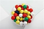 Coloured bubble gum balls in a bowl (overhead view)