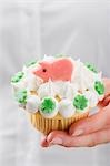 Hand hält Cupcake mit Marzipan Schwein