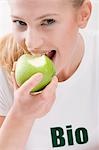 Woman eating organic green apple