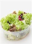 Mixed salad leaves in plastic container