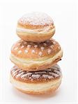 Three doughnuts dusted with icing sugar, stacked