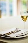 Place-setting and glass of white wine