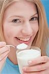 Young woman eating natural yoghurt