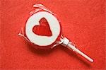Lollipop with heart on red background