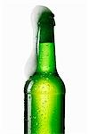 Beer frothing out of green bottle