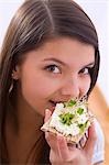 Girl eating crisp bread with cottage cheese and cress