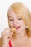 Woman with blond hair eating a mini sandwich biscuit