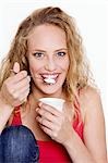 Jeune femme mangeant yaourt nature