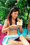 Woman drinking coconut milk by pool