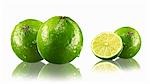 Limes, whole and halved, with drops of water and reflections