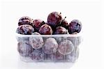 Fresh plums in plastic container