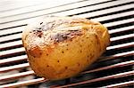 Barbecued potato on barbecue rack