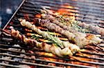 Belly pork kebabs with rosemary on barbecue