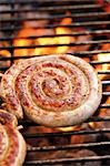 Coiled sausage on barbecue rack (close-up)