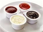 Four different dips in plastic pots
