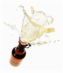 Beer splashing out of brown bottle