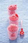 Strawberry yoghurt ice cream in glasses, plastic spoon