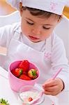 Petite fille à la toque de manger des fraises