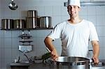 Chef en mélangeant une casserole sur la plage