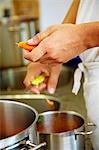 Chef in commercial kitchen peeling carrots