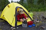 Femelle au camp en petite tente sur la rivière Twentymile à l'été de la forêt nationale de Chugach centre-sud de l'Alaska